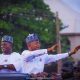 a group of men in white shirts and hats waving