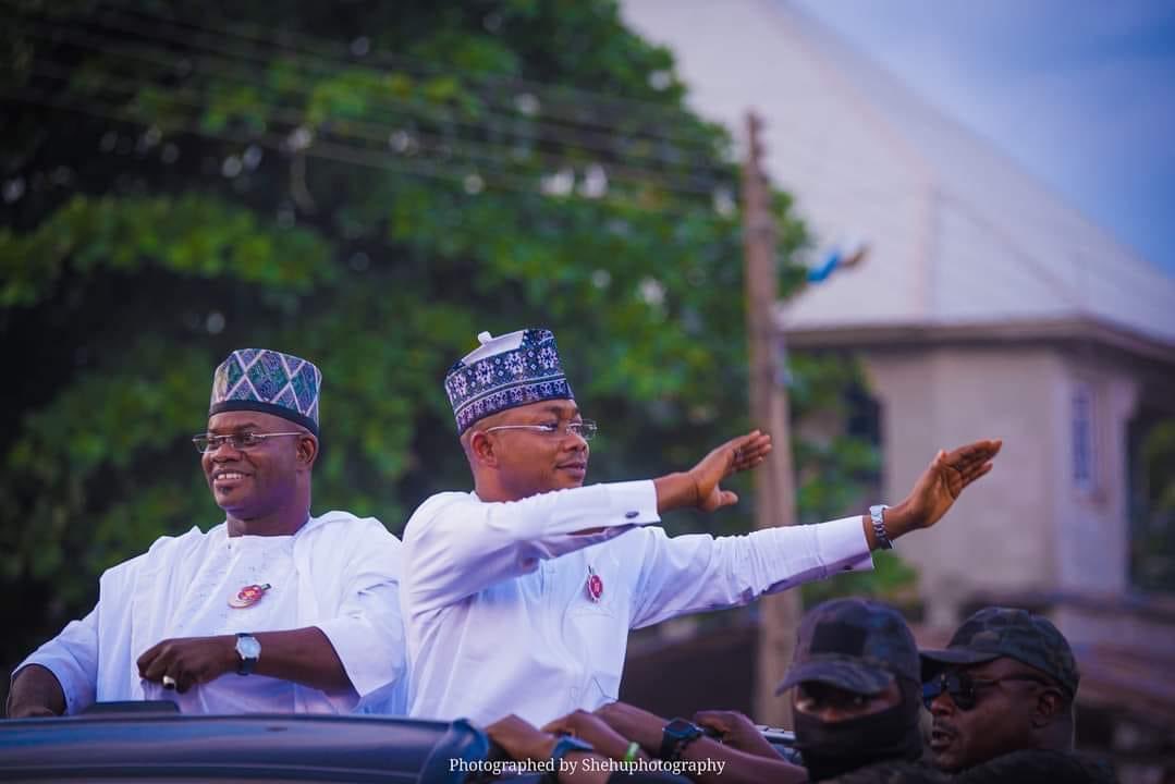 a group of men in white shirts and hats waving